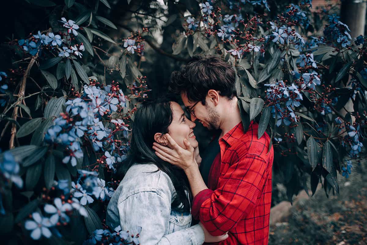 couple touching noses in a garden
